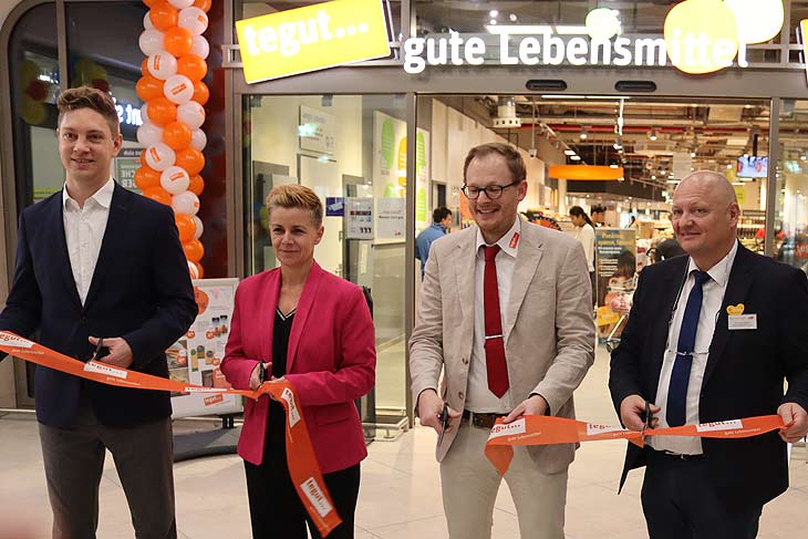 Schnitten gemeinsam das symbolische orange Band zur Neueröffnung des neuen tegut... Supermarktes im PERLACH PLAZA durch (von links): Florian Alexander Buchholz (Leiter Expansion Südbayern tegut...), Ulrike Manz (Geschäftsleiterin Vertrieb Supermärkte tegutx), Maximilian Schill (Filialgeschäftsführer tegut... München) und Christian Göpfert (Gebietsverantwortlicher Vertrieb tegut... (ªFoto.Martin Schmitz)